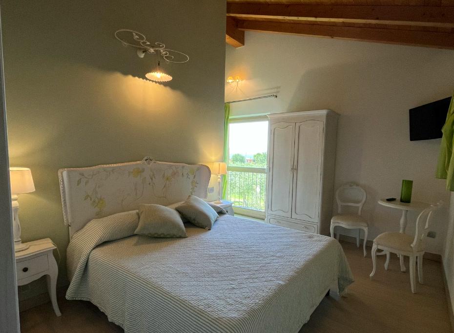 Camera Superior con letto matrimoniale, soffitto in legno e finestra sul verde