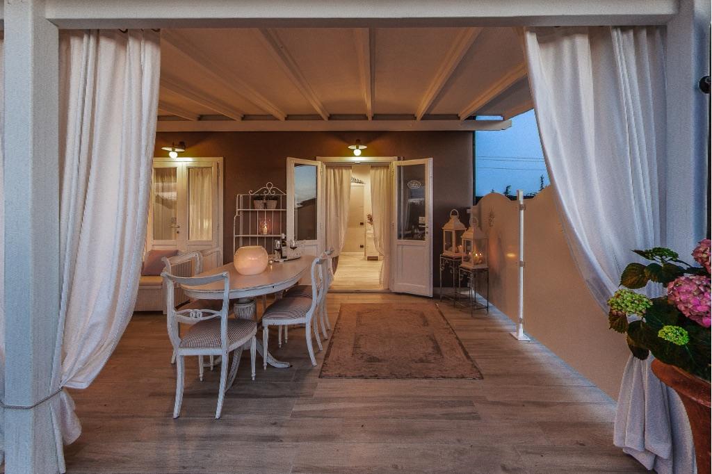 Veranda con tende bianche illuminata la sera